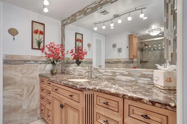 a bathroom with a granite countertop sink and a mirror