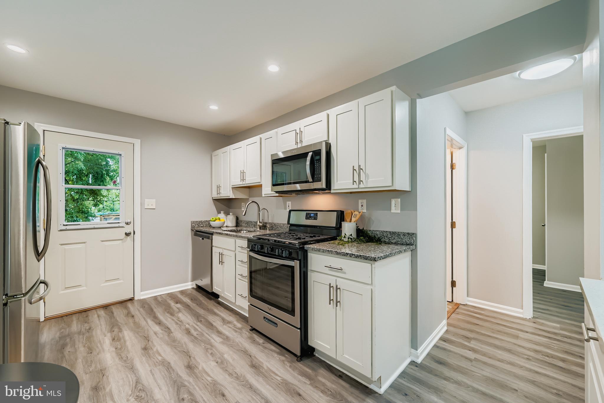 1229 North Point Road Dundalk, MD 21222 - Photo 4 of 28 a kitchen with granite countertop a stove top oven and cabinets