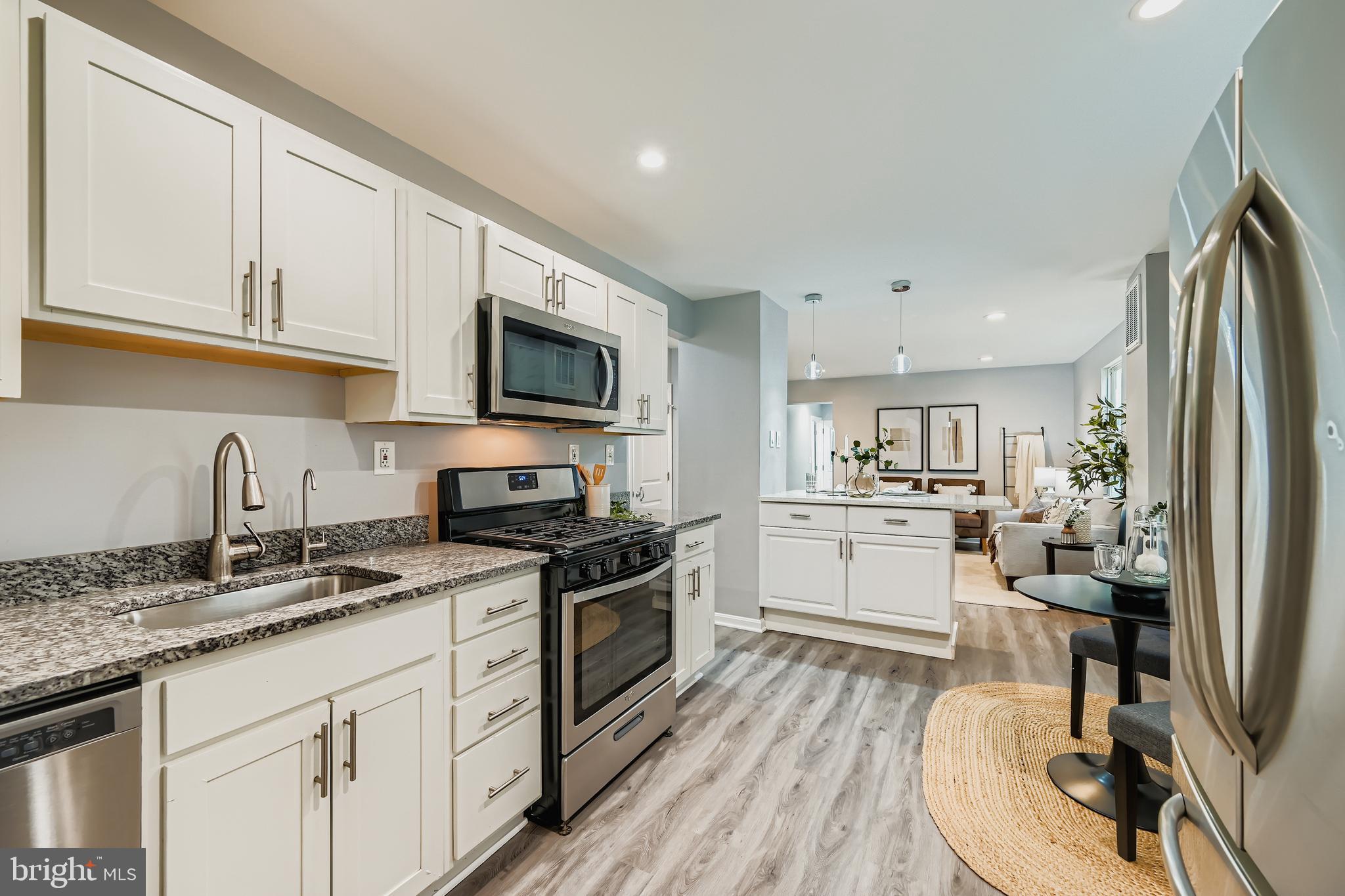 1229 North Point Road Dundalk, MD 21222 - Photo 6 of 28 a kitchen with granite countertop a sink appliances cabinets and a counter space