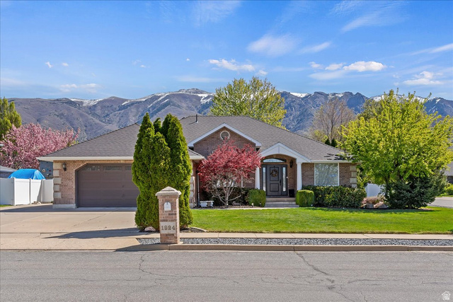 1924 North 2000th Street East Layton, UT 84040 - Photo 2 of 41 View of front facade featuring a front lawn, an attached garage, brick siding, a mountain view, and driveway