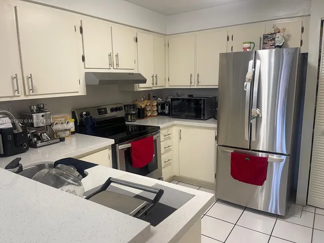 a kitchen with stainless steel appliances a refrigerator sink and cabinets