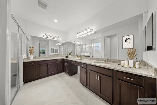 a large bathroom with a double vanity sink a mirror and a bathtub