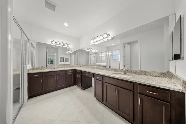 a spacious bathroom with a granite countertop sink a mirror a toilet and a bathtub