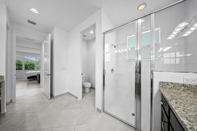 a bathroom with a granite countertop sink mirror and toilet