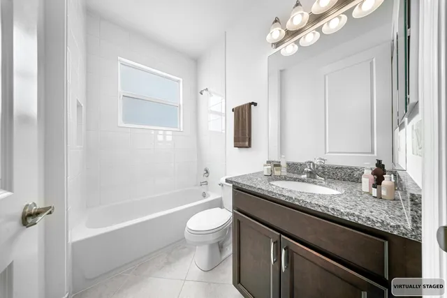 a bathroom with a granite countertop sink a toilet and bathtub