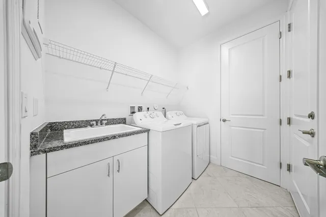 a utility room with cabinets washer and dryer