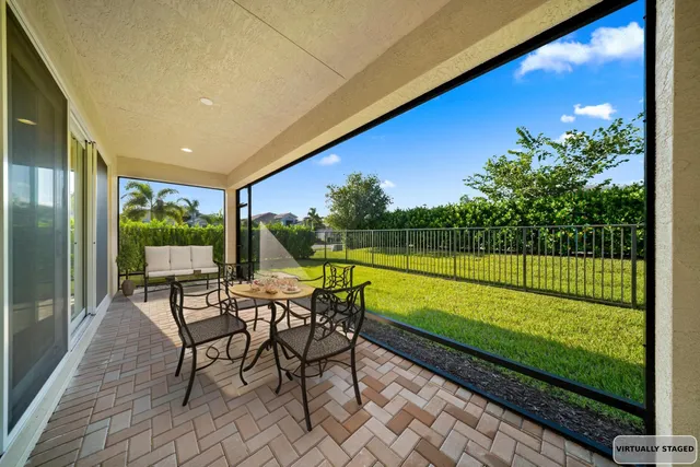 a view of a chairs and table in patio with a small yard