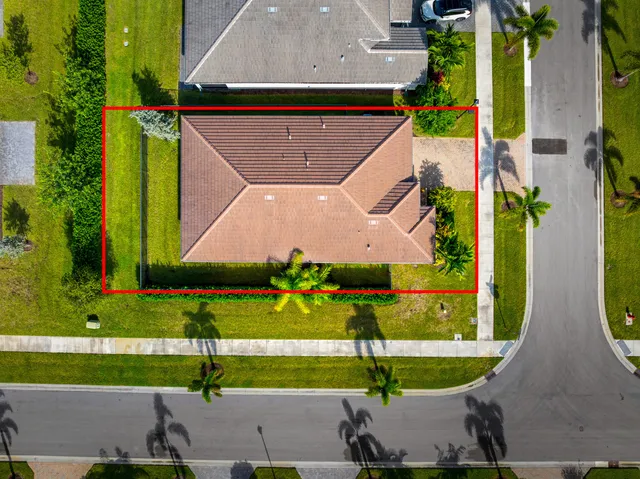 an aerial view of a house with a yard and a large pool