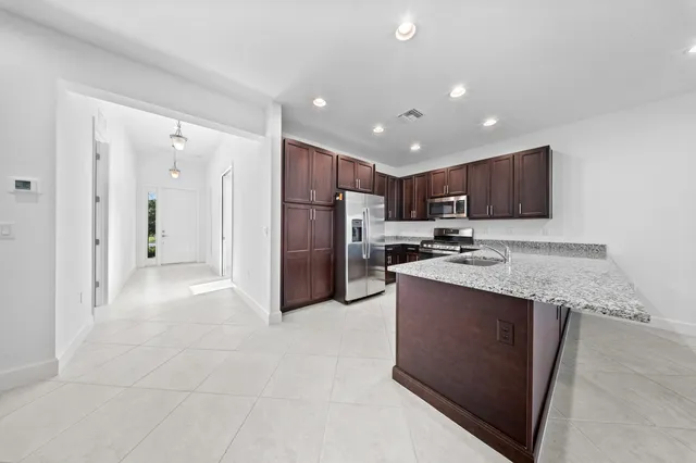 a kitchen with stainless steel appliances granite countertop a refrigerator stove top oven and sink
