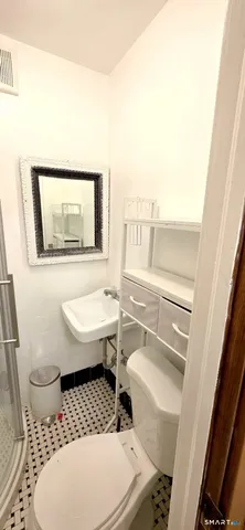 a bathroom with a toilet a sink and a mirror