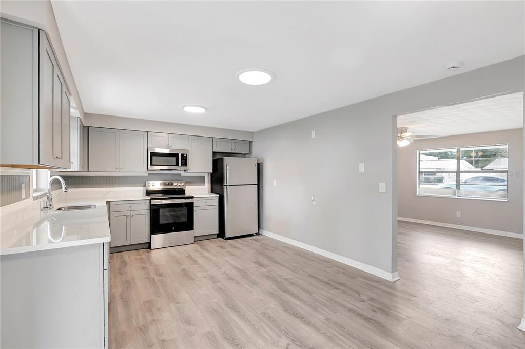 5900 Beech Street Zephyrhills, FL 33542 - Photo 12 of 37 a kitchen with granite countertop a refrigerator and a stove top oven