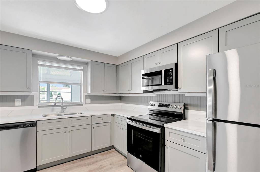 5900 Beech Street Zephyrhills, FL 33542 - Photo 15 of 37 a kitchen with white cabinets stainless steel appliances and a window