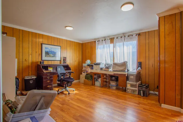 a view of a workspace with furniture and wooden floor