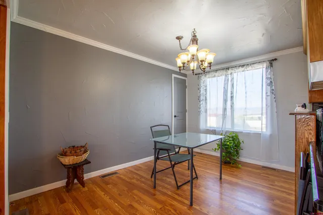 a dining room with furniture a chandelier and wooden floor