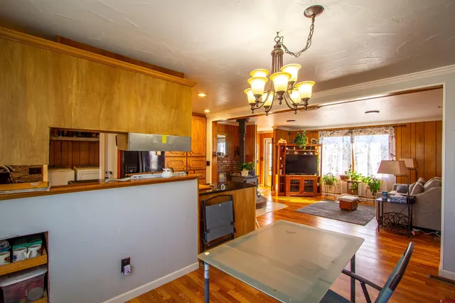 a kitchen with stainless steel appliances wooden floor and large windows