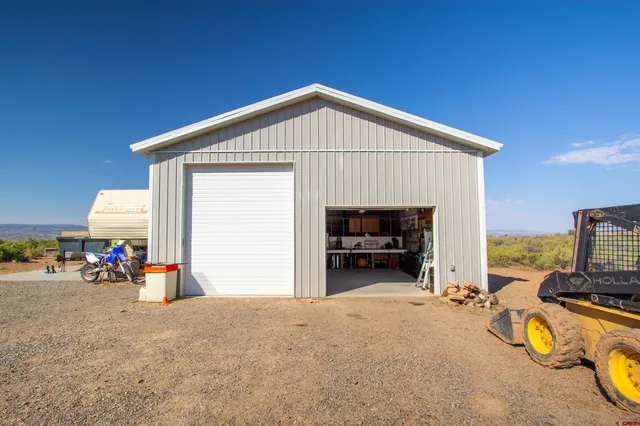 a view of a house with a garage and furniture