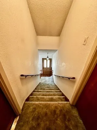 a view of a bedroom with wooden floor and chair