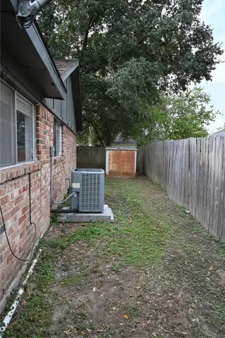 a view of a backyard with wooden fence and a bench