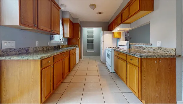 a kitchen with stainless steel appliances granite countertop a stove a sink and a refrigerator