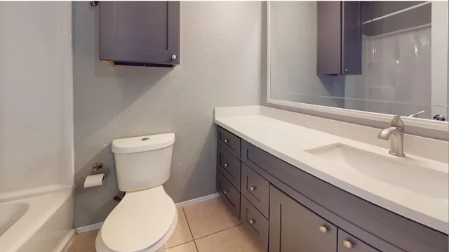a white toilet sitting next to a bathroom sink