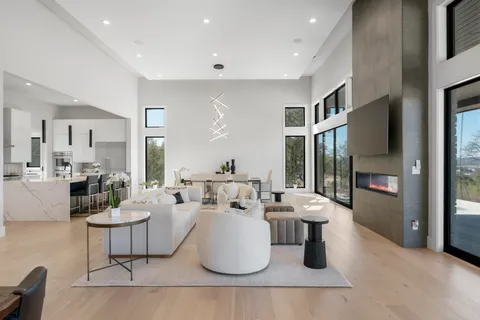 a large white kitchen with a large window and stainless steel appliances