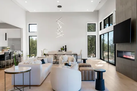 a living room with stainless steel appliances kitchen island granite countertop a couch and white cabinets