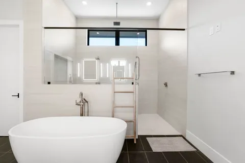 a en suite bathroom with a shower sink and mirror
