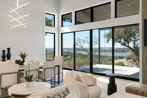a living room with furniture a flat screen tv and a large window