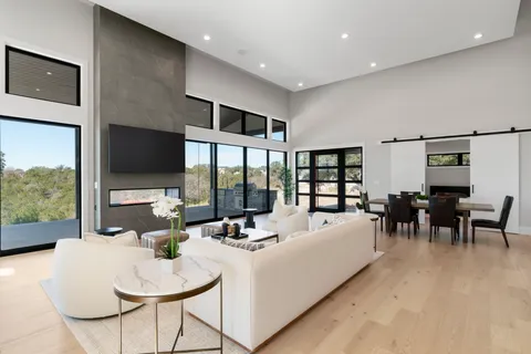 a large white kitchen with a large window and stainless steel appliances