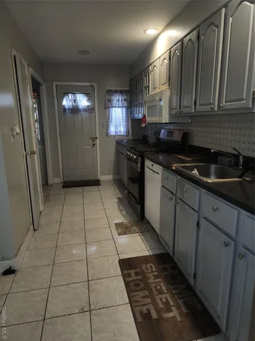 a kitchen with a sink a stove and cabinets