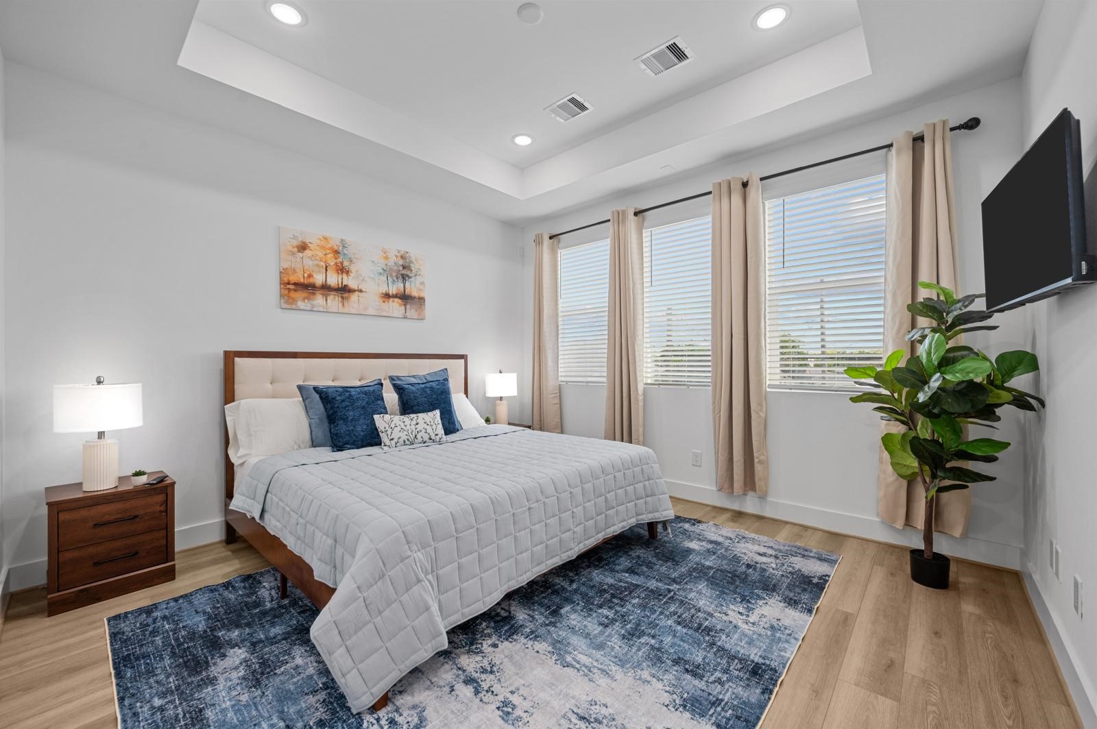 a bedroom with a bed a television and potted plant
