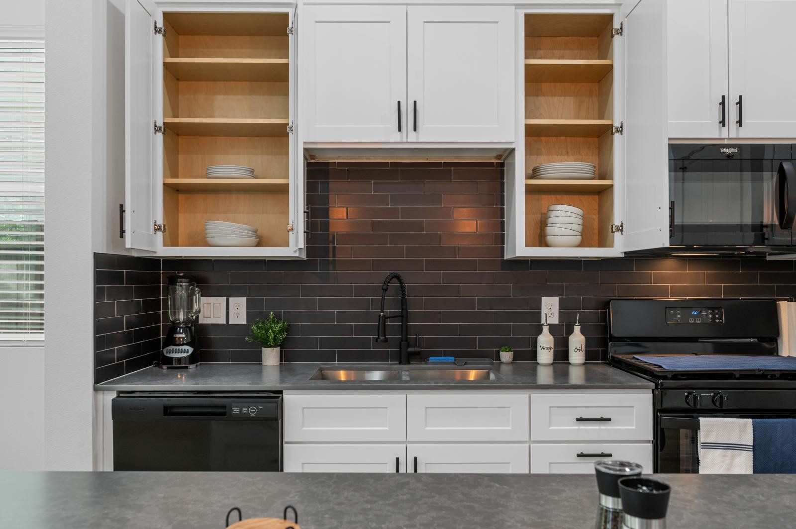4201 Stassen Street Houston, TX 77051 - Photo 12 of 32 a kitchen with stainless steel appliances kitchen island granite countertop a stove and a microwave
