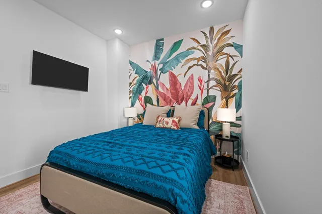 a bedroom with a bed and painting on the wall