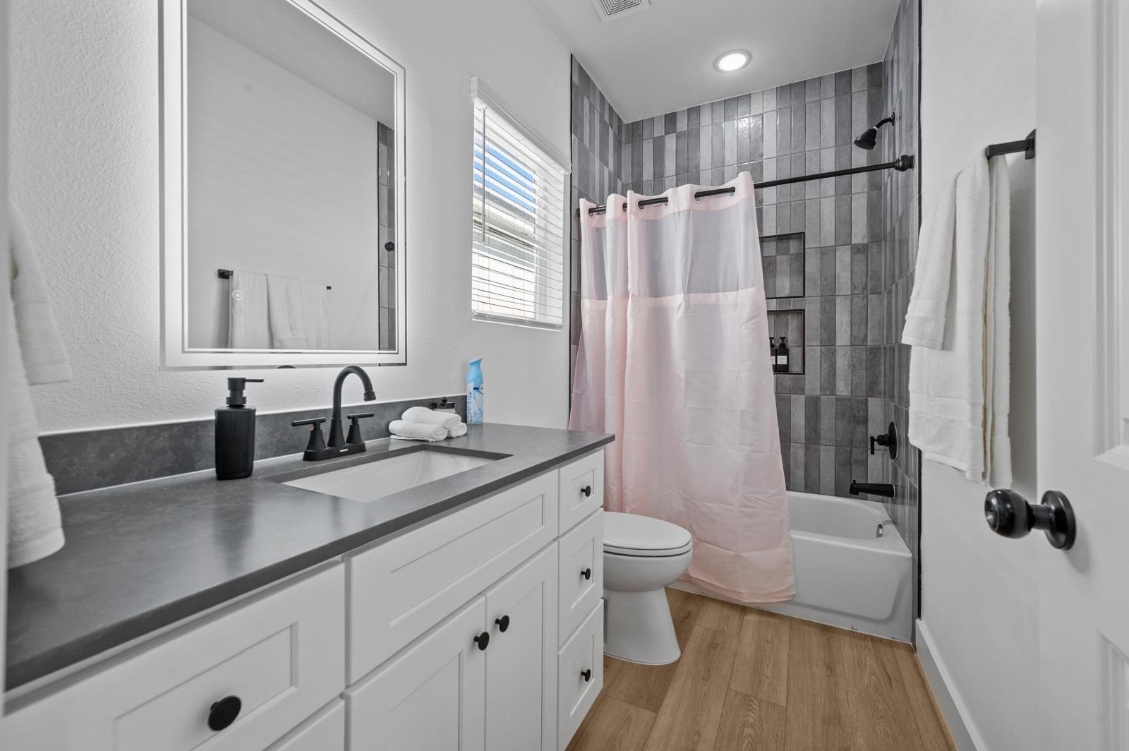 4201 Stassen Street Houston, TX 77051 - Photo 24 of 32 a bathroom with a granite countertop sink a toilet a mirror a vanity and shower