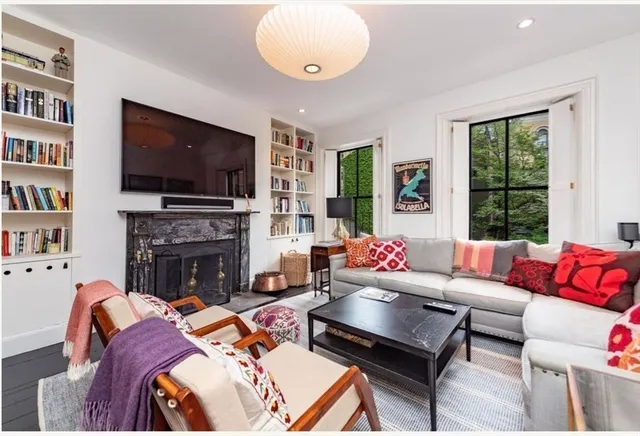 a living room with furniture a flat screen tv and a fireplace