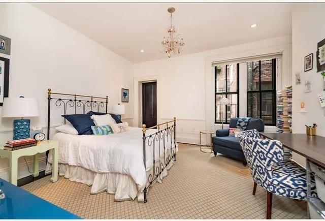 a bedroom with a bed a couch and dresser