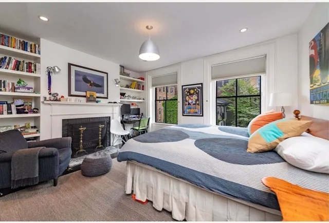 a bedroom with a bed a couch and large window