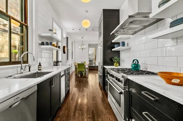 a kitchen with stainless steel appliances granite countertop a sink and a stove