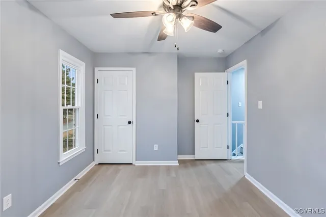an empty room with fan and windows