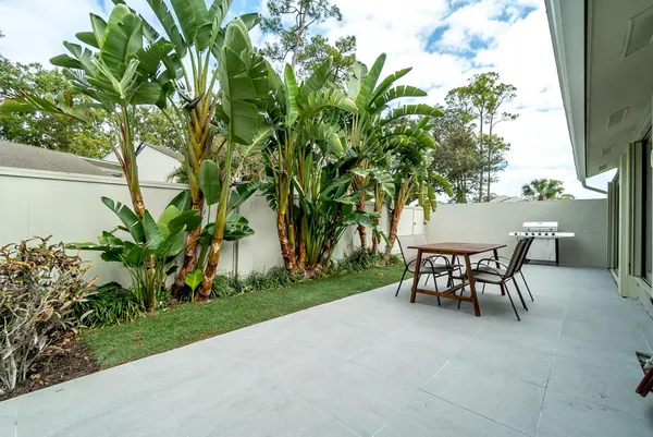 a view of a yard with a table and chairs in patio