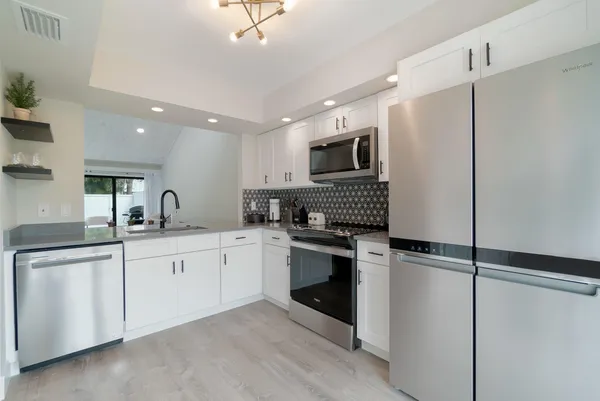 a kitchen with sink cabinets and stainless steel appliances