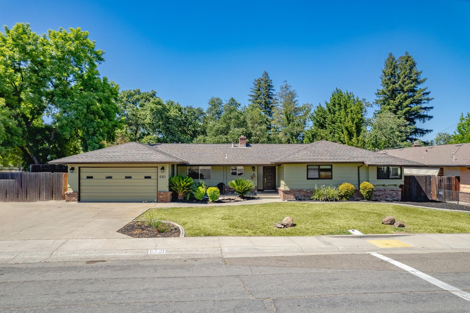 a front view of a house with a yard and trees