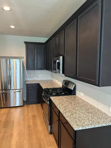 a kitchen with kitchen island a counter top space appliances and cabinets
