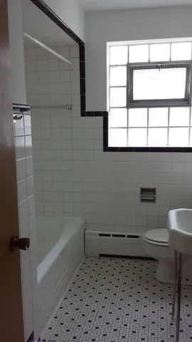 a view of an empty room with wooden floor and windows