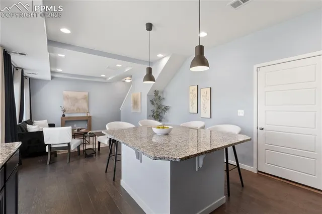 a kitchen with a table chairs and white cabinets