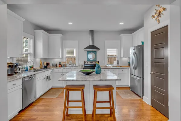 a kitchen with stainless steel appliances granite countertop a refrigerator and a stove top oven