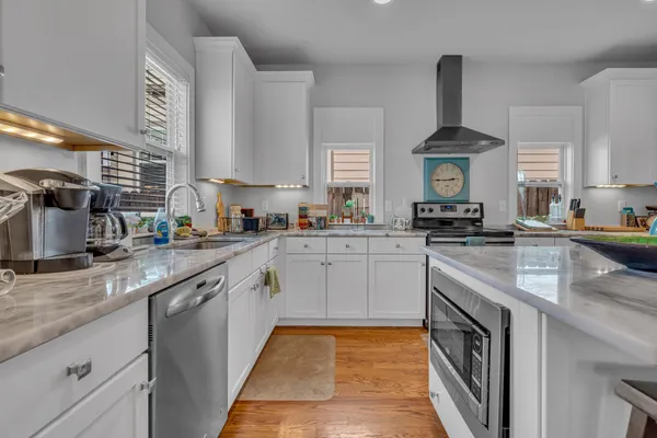 a kitchen with stainless steel appliances granite countertop a sink stove and cabinets