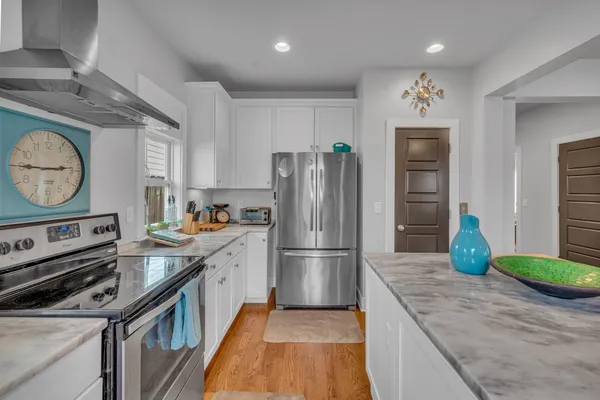 a kitchen with kitchen island granite countertop a stove a refrigerator and a sink