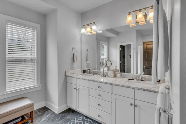 a bathroom with double vanity and a mirror