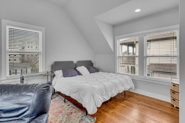 a bedroom with a bed and a large window